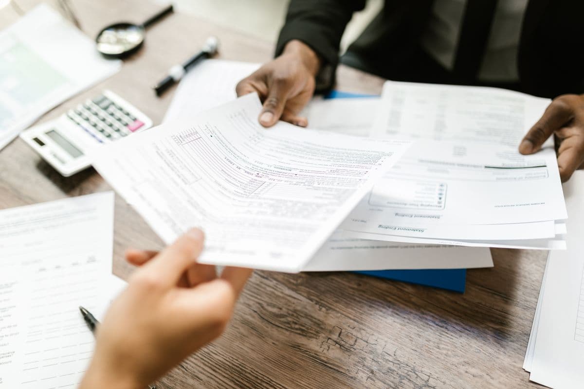 Hands sorting and correcting stacks of financial paperwork
