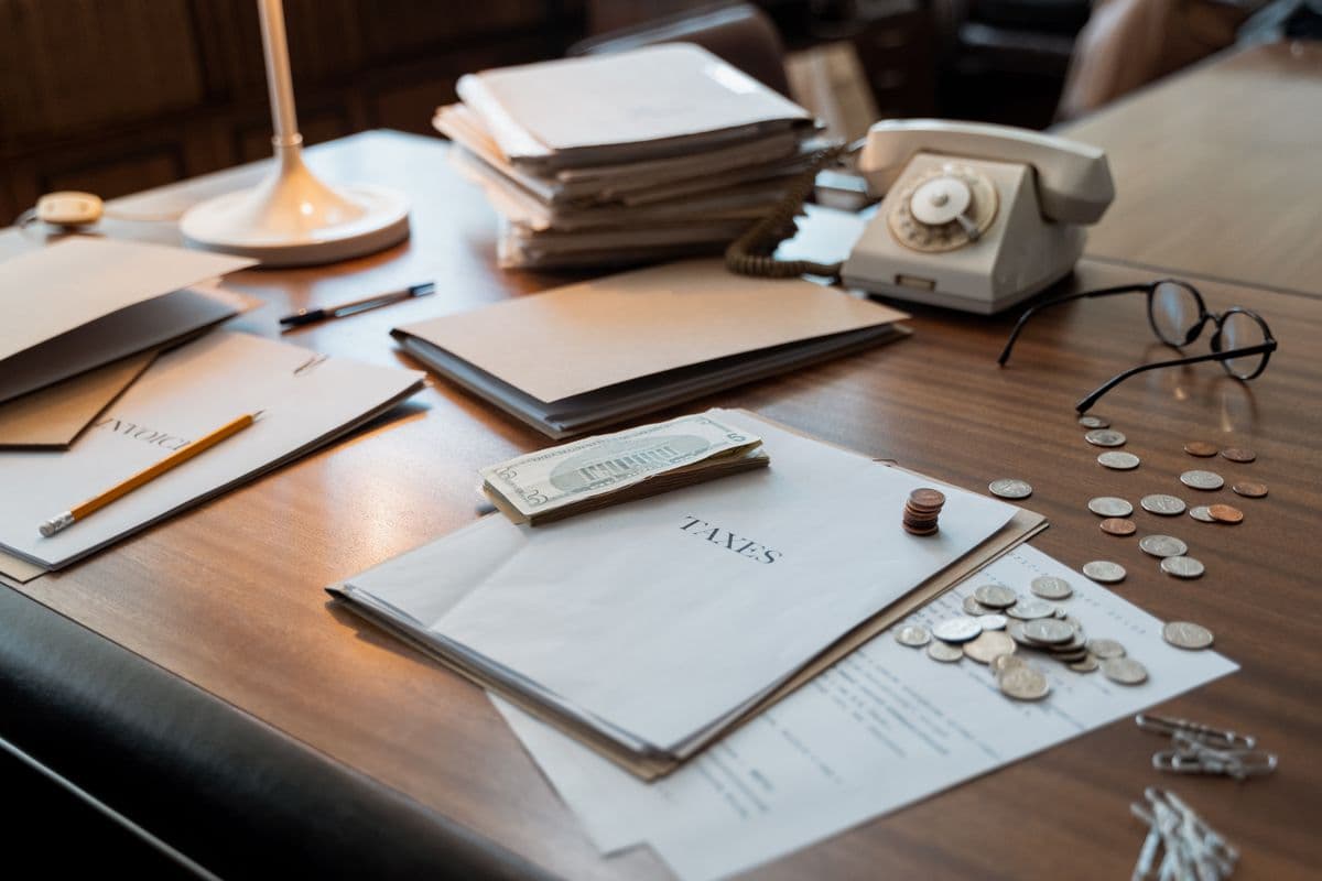 A desk being set up with tax folders, a calculator, and ledgers